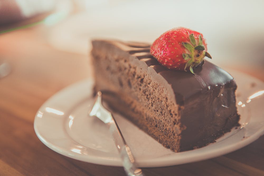 chocolate cake with a red strawberry on top of it. 