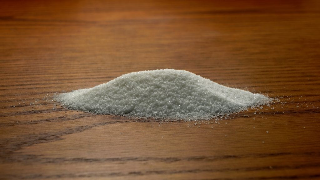 Cannabis-infused sugar on a brown oak table