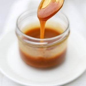 Cannabis infused caramel in a jar with a spoon scooping some of the caramel