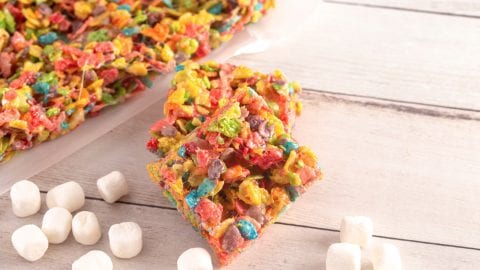 overhead shot of cannabis infused fruity pebble bars on a wooden table with marshmallows spread around the bars